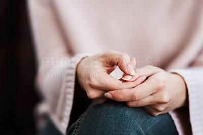 Buy stock photo Cropped shot of a woman sitting on a sofa and feeling anxious