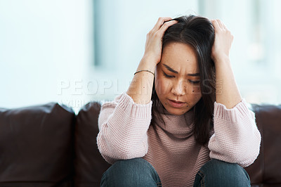 Buy stock photo Shot of a young woman experiencing mental anguish at home