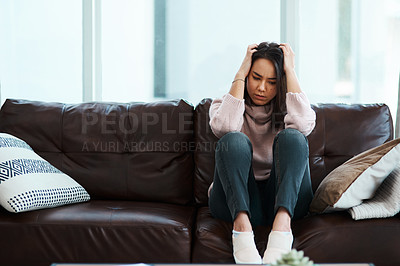 Buy stock photo Shot of a young woman experiencing mental anguish at home