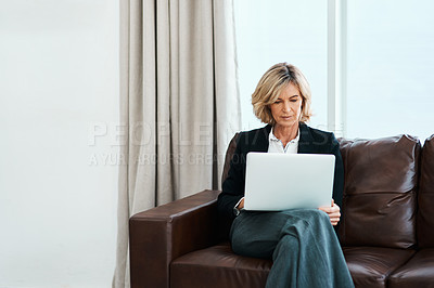 Buy stock photo Shot of a mature psychologist sitting on a sofa and using a laptop
