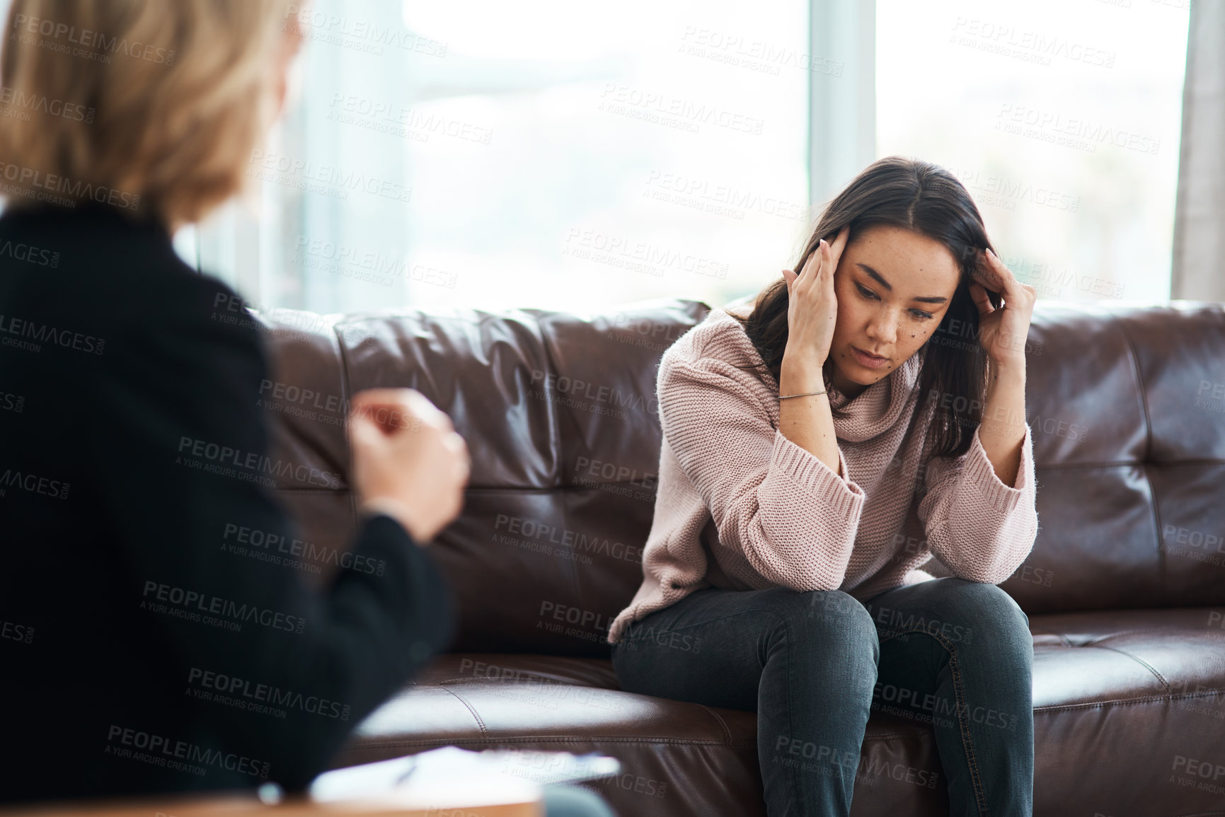 Buy stock photo Shot of a young woman having a therapeutic session with a psychologist