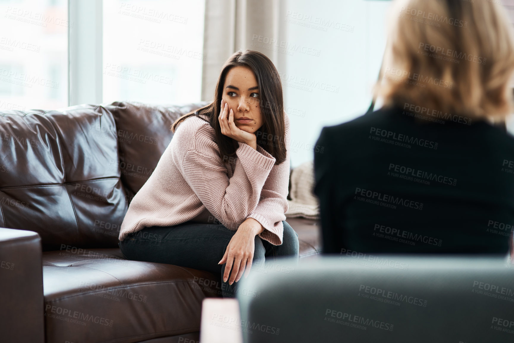 Buy stock photo Shot of a young woman having a therapeutic session with a psychologist