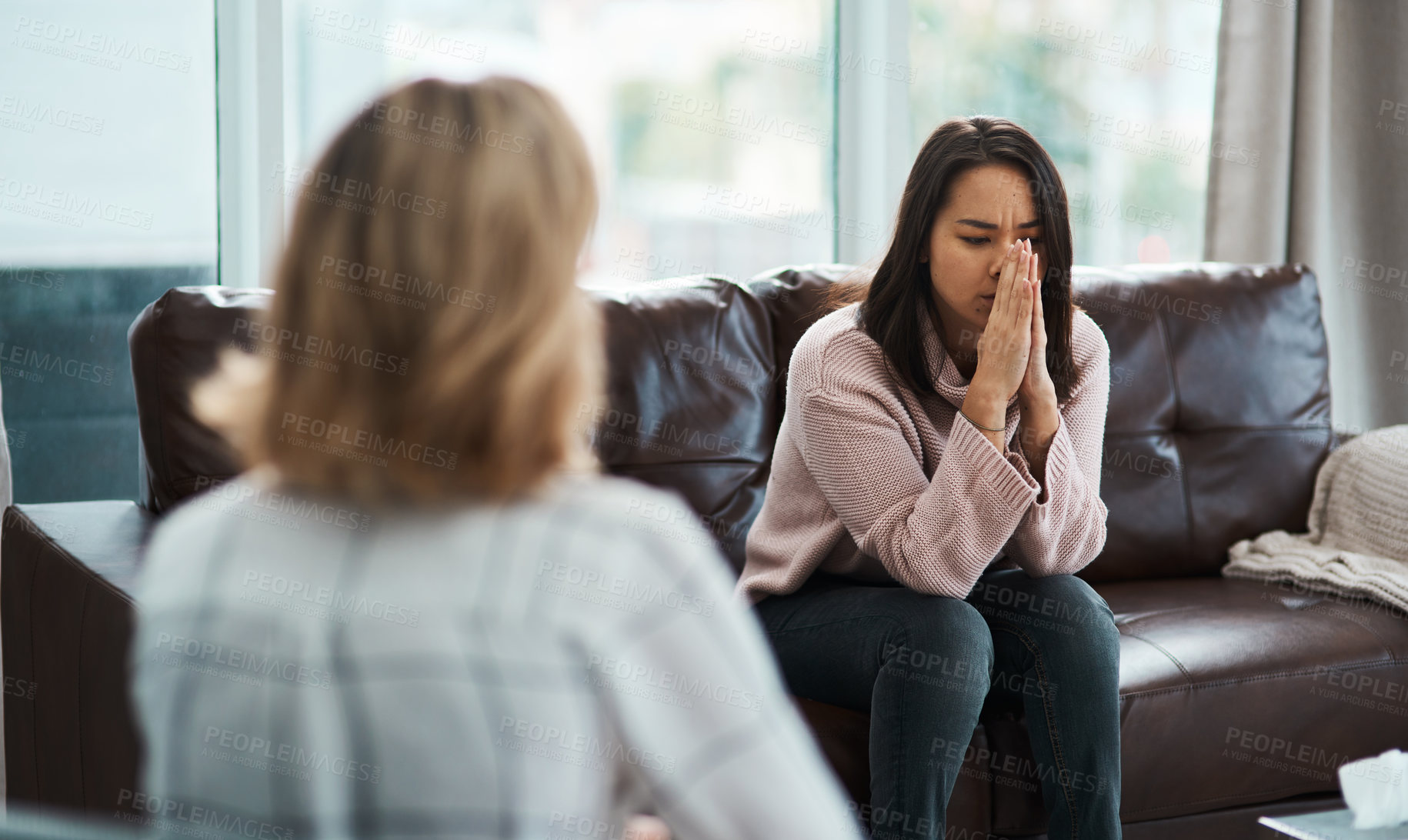 Buy stock photo Shot of a young woman having a therapeutic session with a psychologist