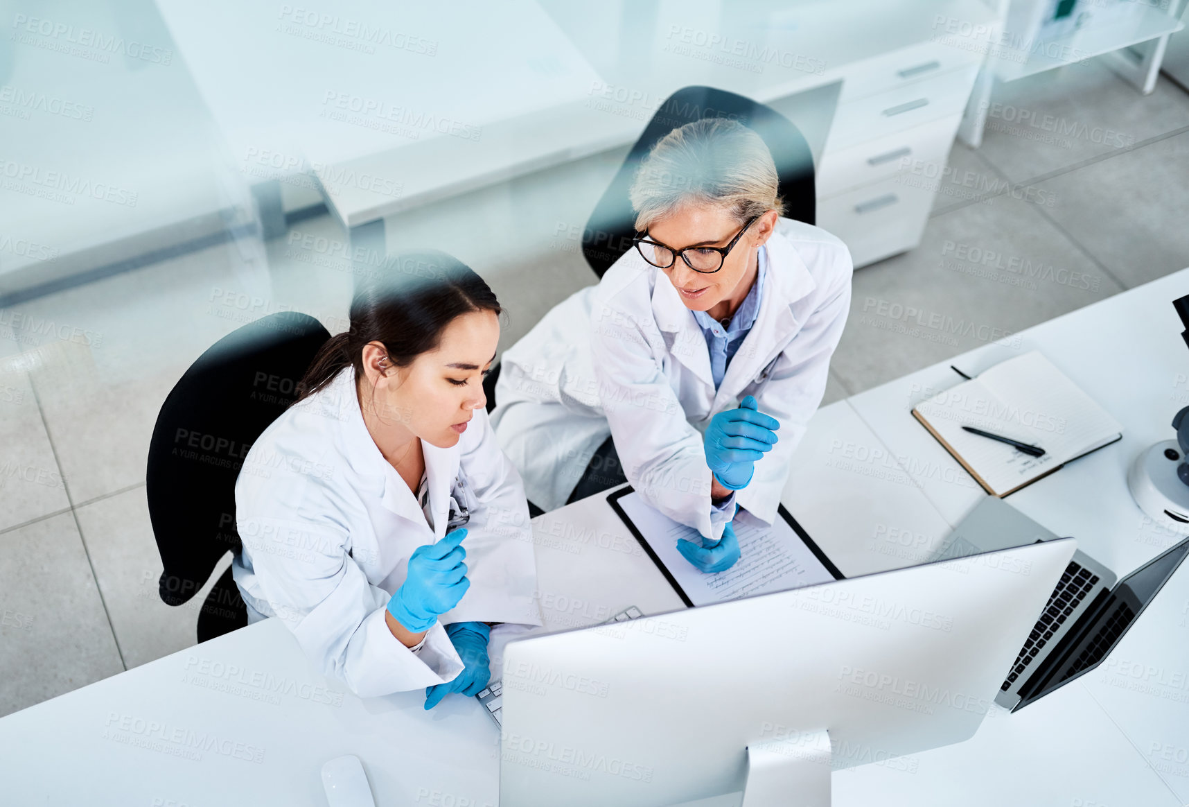 Buy stock photo Shot of two scientists working together on a computer in a lab