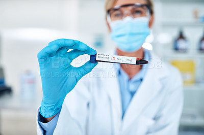 Buy stock photo Closeup shot of an unrecognisable scientist holding a blood filled test tube with a positive Covid-19 result on its label