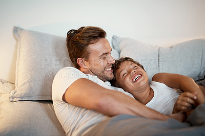 Buy stock photo Shot of a man and his son lying in a bed together