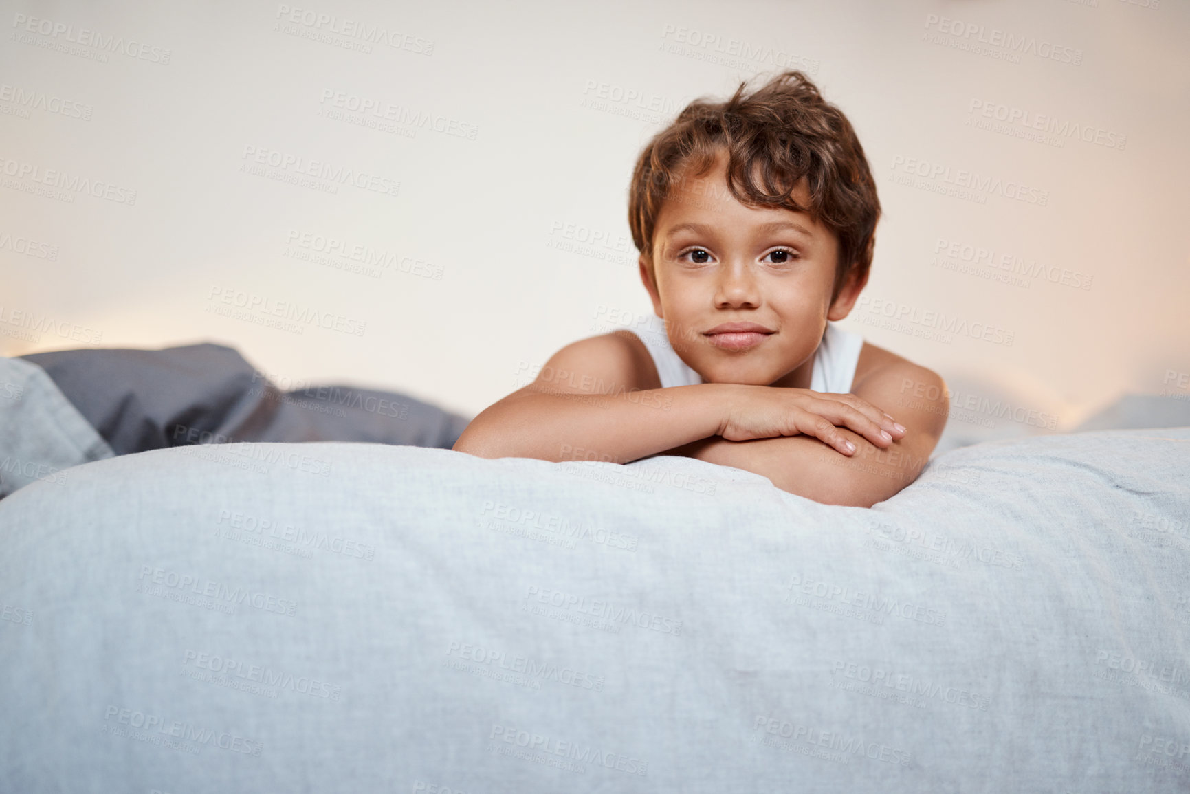 Buy stock photo Shot of an adorable young boy lying on his bed