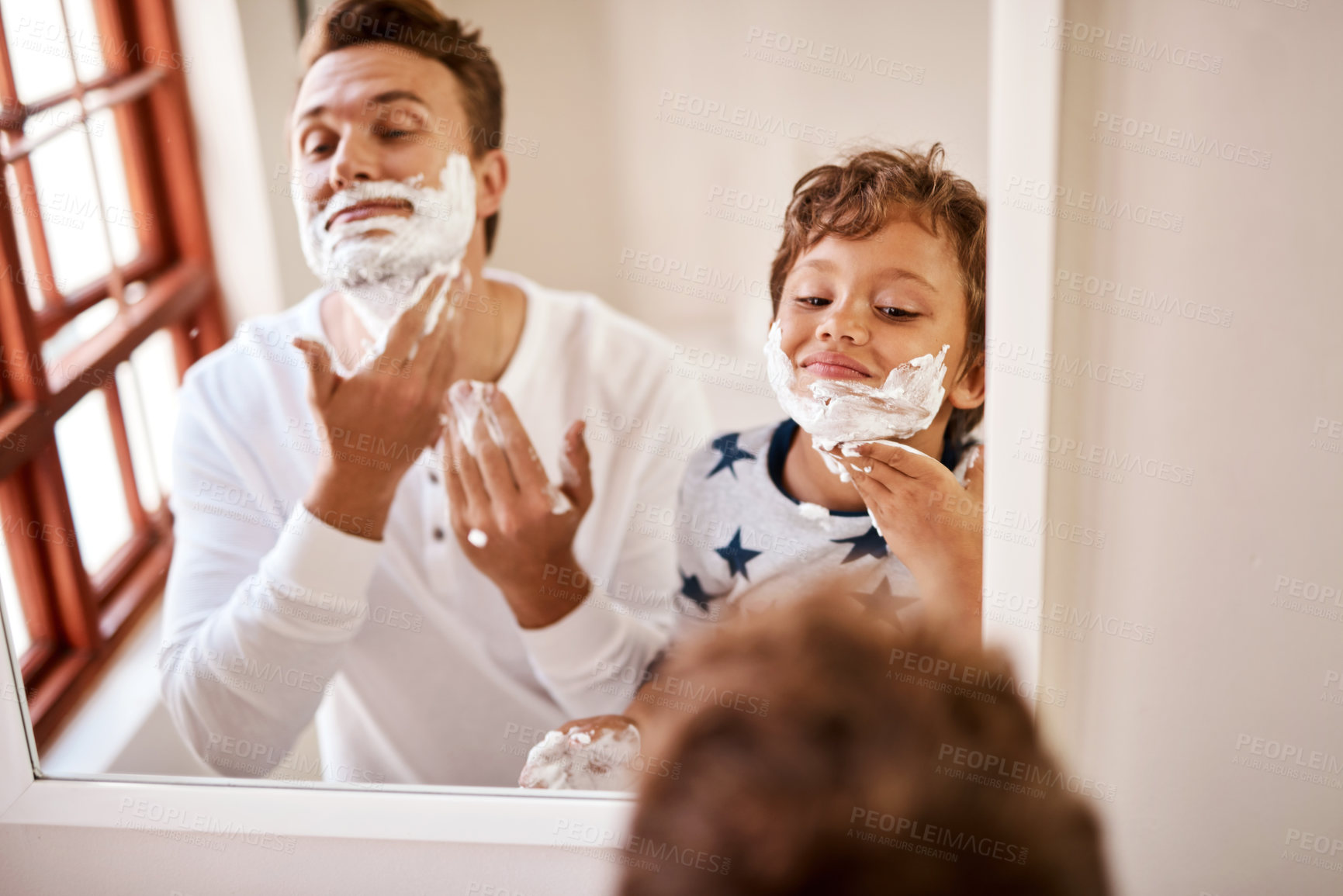 Buy stock photo Shot of a man teaching his young son how to shave at home