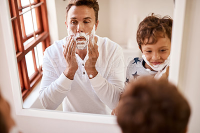 Buy stock photo Shot of a man teaching his young son how to shave at home
