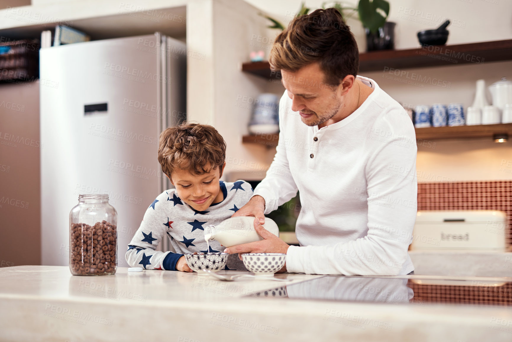 Buy stock photo Milk, cereal and father with child in kitchen for breakfast in home on weekend for bonding. Happy, porridge and dad helping boy kid prepare morning meal for nutrition, vitamins or calcium at house.