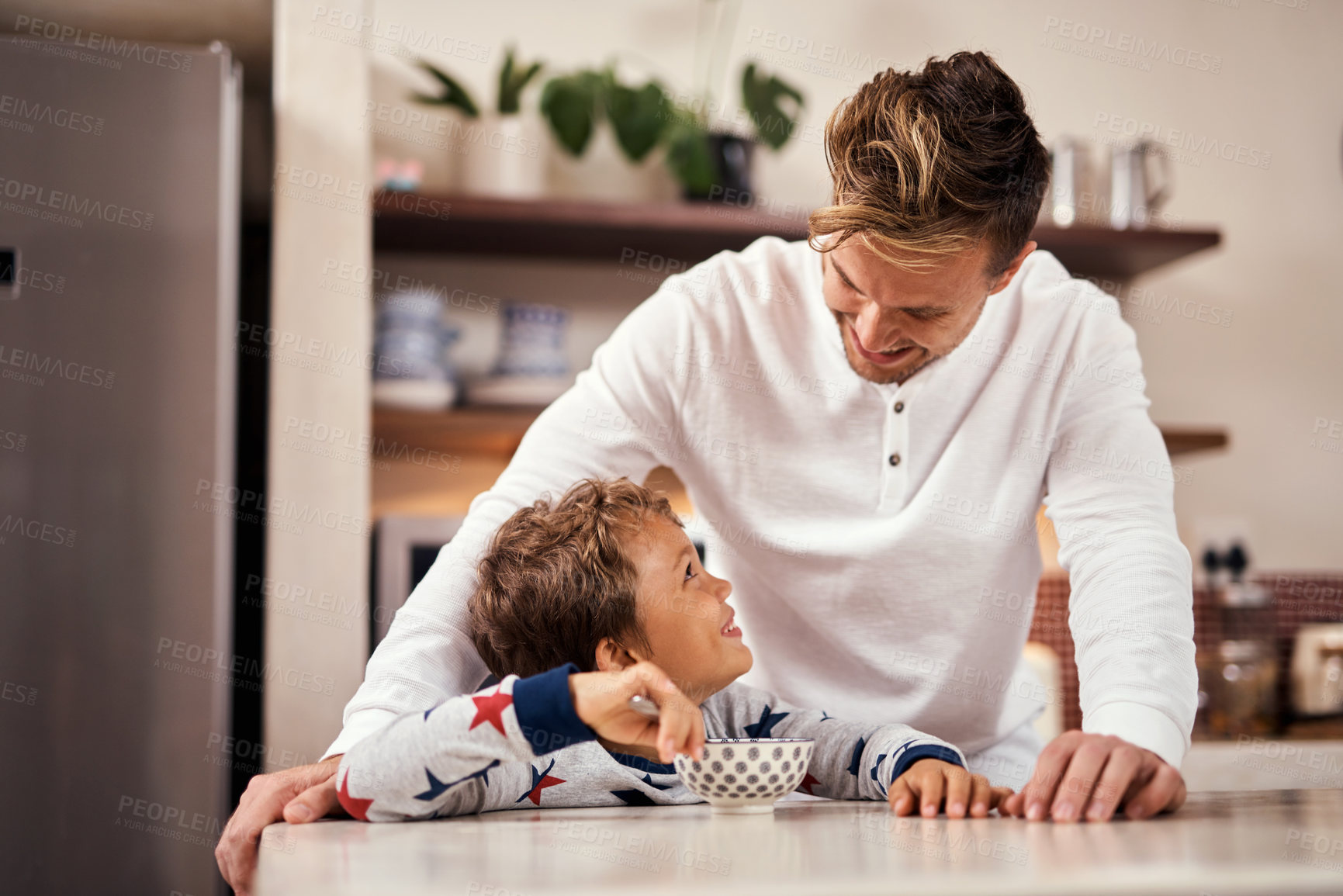 Buy stock photo Shot of a young boy having breakfast while sitting at home with his father