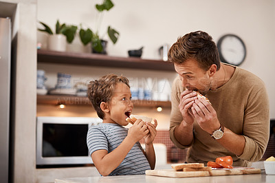 Buy stock photo Cropped shot of a man and his his having a sandwich at home