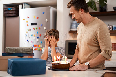 Buy stock photo Shot of a man surprising his son with cake and gifts on his birthday