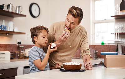 Buy stock photo Shot of a young boy and his father having cake at home