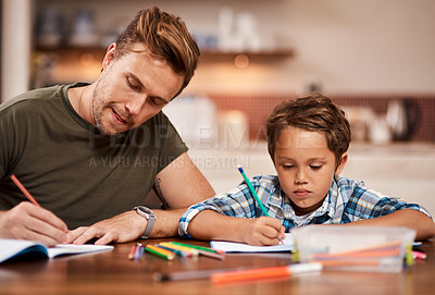 Buy stock photo Shot of a man sitting with his son while he does his homework