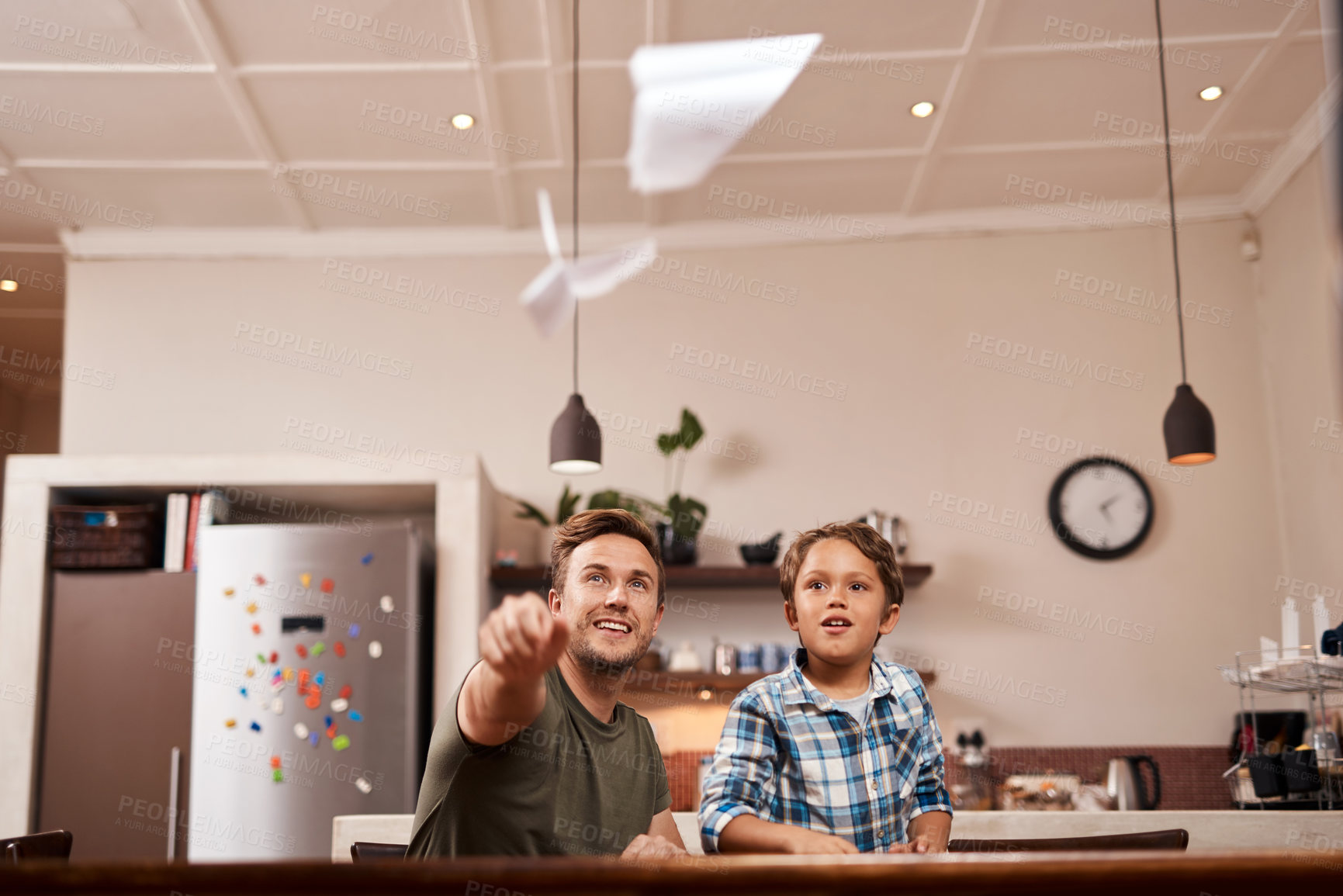 Buy stock photo Cropped shot of a man and his young son playing with paper planes at home