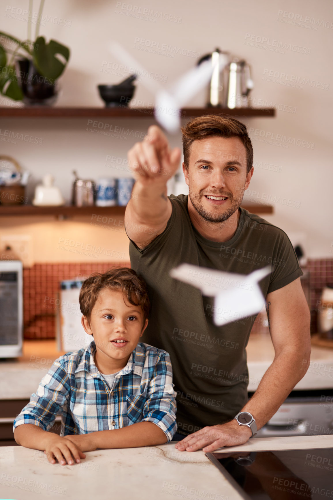 Buy stock photo Cropped shot of a man and his young son playing with paper planes at home