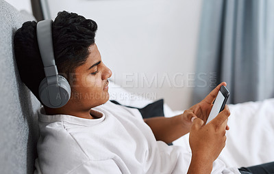 Buy stock photo Relax, bedroom and man with smartphone and headphones listening to podcast streaming service. Bed, music and internet with young person at home with online search and radio app or audio playlist