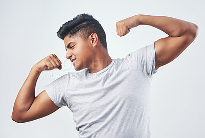 Buy stock photo Studio shot of a young man flexing against a white background