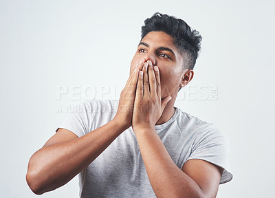 Buy stock photo Studio shot of a young man sitting against a white background
