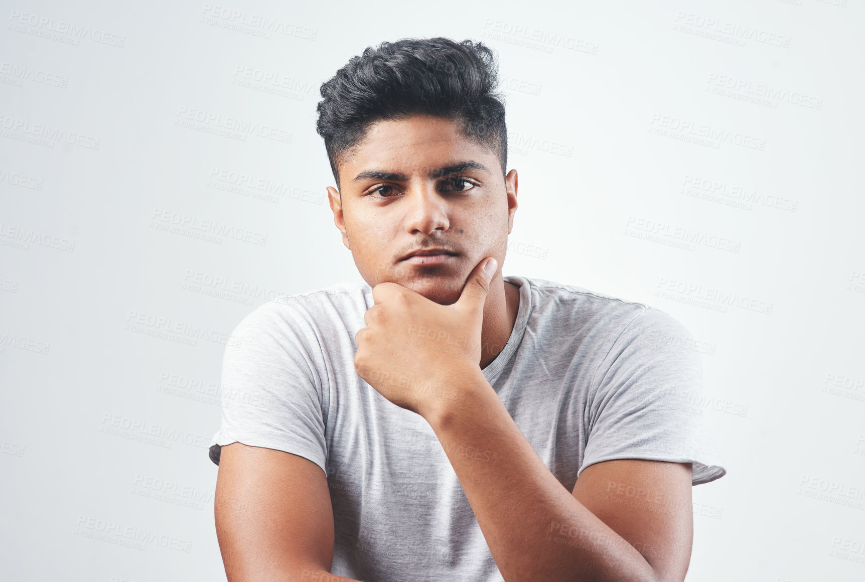 Buy stock photo Indian man, portrait and fashion with casual style, tshirt or hairstyle in studio on a white background. Young, male person or handsome gen z model with serious face, confidence or cool attittude 