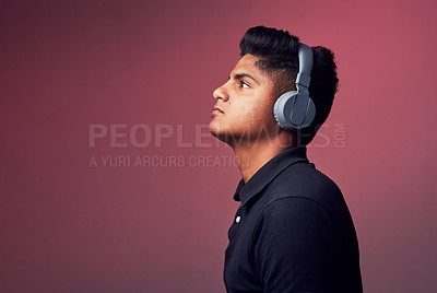 Buy stock photo Studio, serious and man with headphones for music, audio track and sad playlist for broken heart. Mockup space, Indian person and equipment by isolated background for podcast, listening and hearing