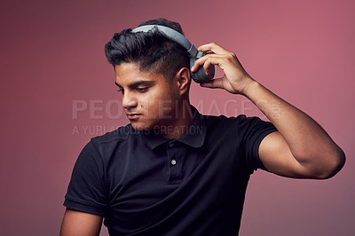 Buy stock photo Studio shot of a handsome young man wearing headphones