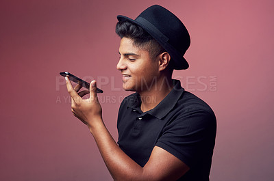 Buy stock photo Studio shot of a young man holding his cellphone