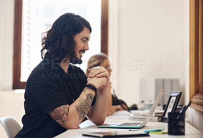 Buy stock photo Young, happy and trendy businessman working on his laptop in an office. Male on an online business meeting talking about his startup. Professional guy sitting at a desk using voice assistant on call