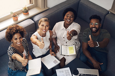 Buy stock photo Shot of a group of young businesspeople showing thumbs up during a meeting in a modern office