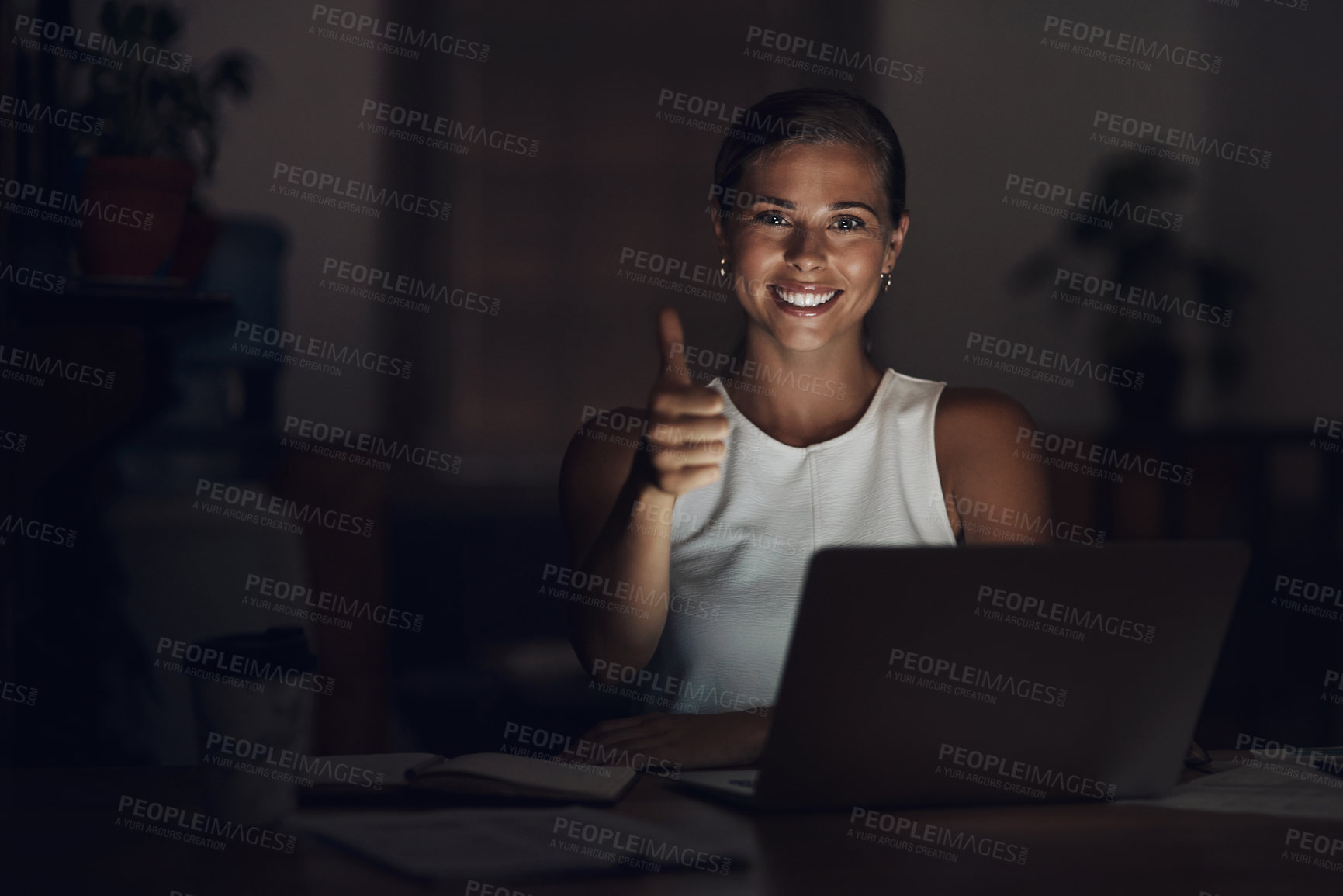 Buy stock photo Portrait of a young businesswoman using a laptop and showing thumbs up during a late night at work