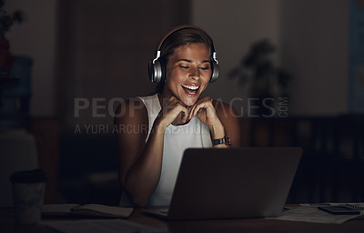 Buy stock photo Shot of a young businesswoman using headphones and a laptop during a late night in a modern office