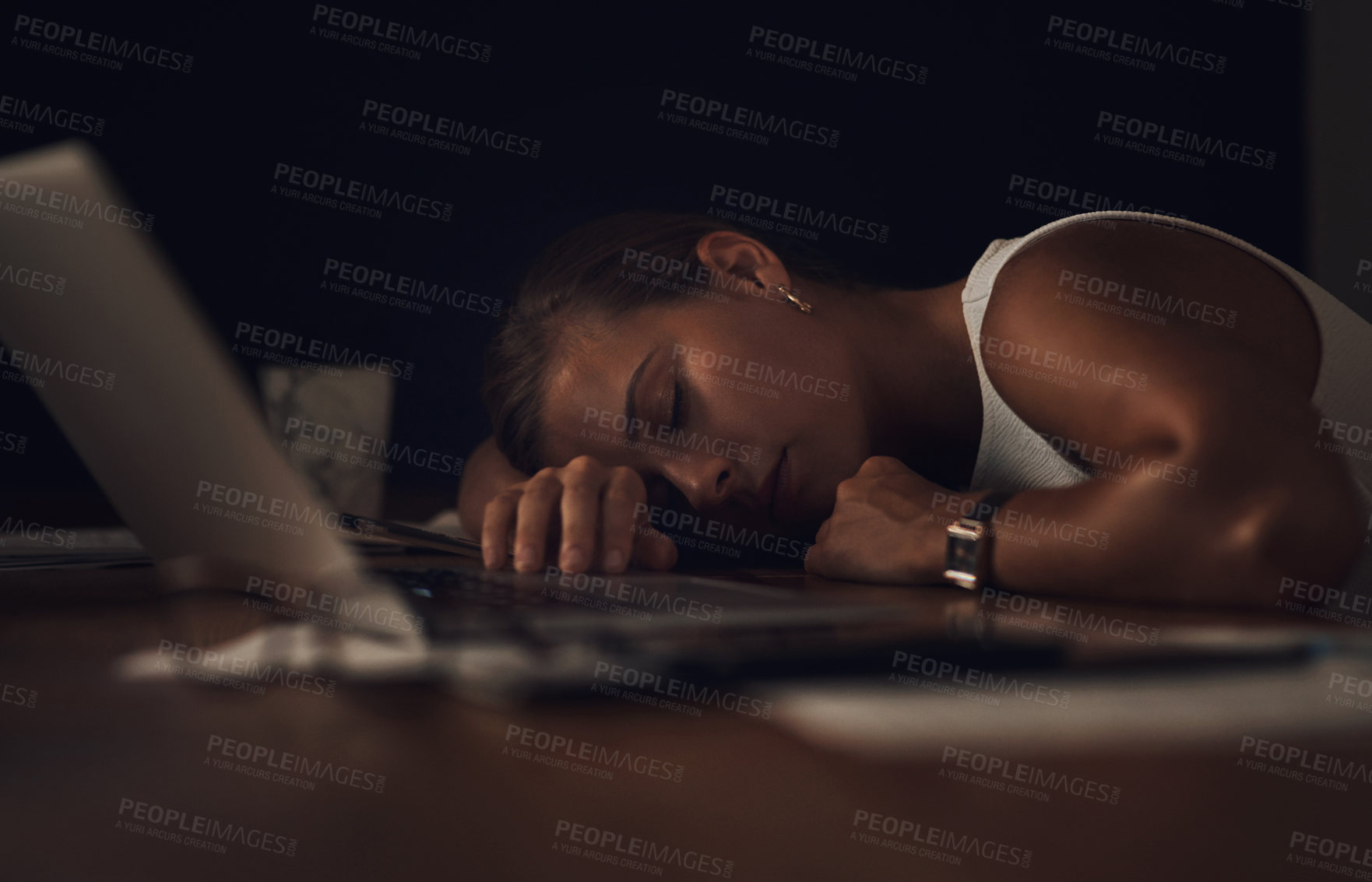 Buy stock photo Shot of a young businesswoman sleeping at her desk during a late night at work