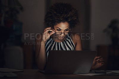 Buy stock photo Shot of a young businesswoman using a laptop and looking surprised during a late night at work
