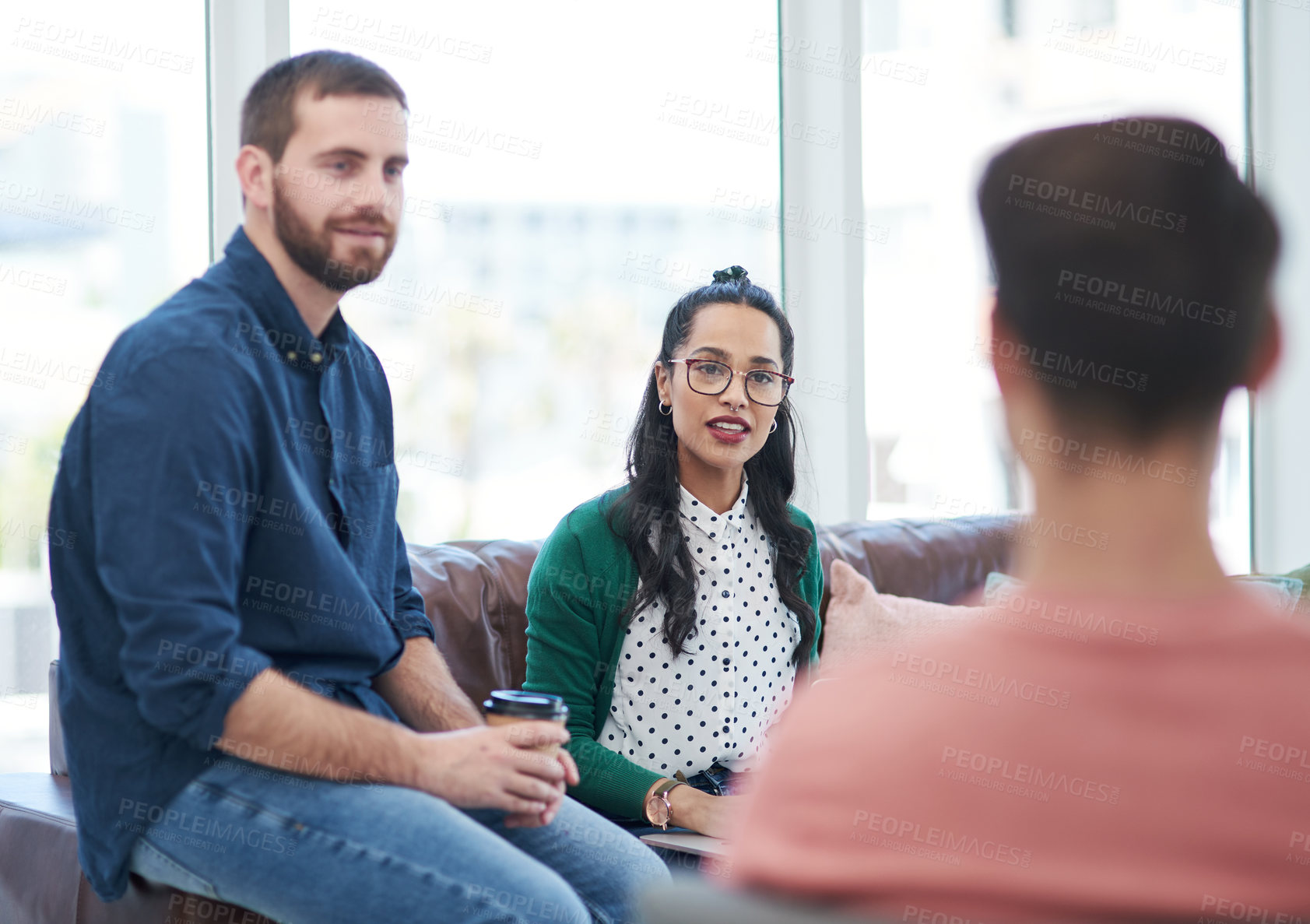 Buy stock photo Shot of a group of young businesspeople having a meeting in a modern office