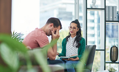 Buy stock photo Shot of a young man crying while having a discussion with a woman in a modern office
