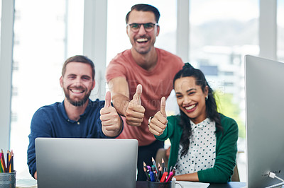 Buy stock photo Portrait of a group of young businesspeople showing thumbs up while using a computer in a modern office