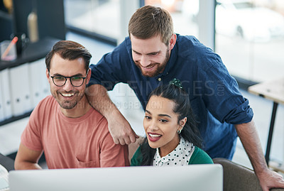 Buy stock photo Shot of a group of young businesspeople using a computer together in a modern office