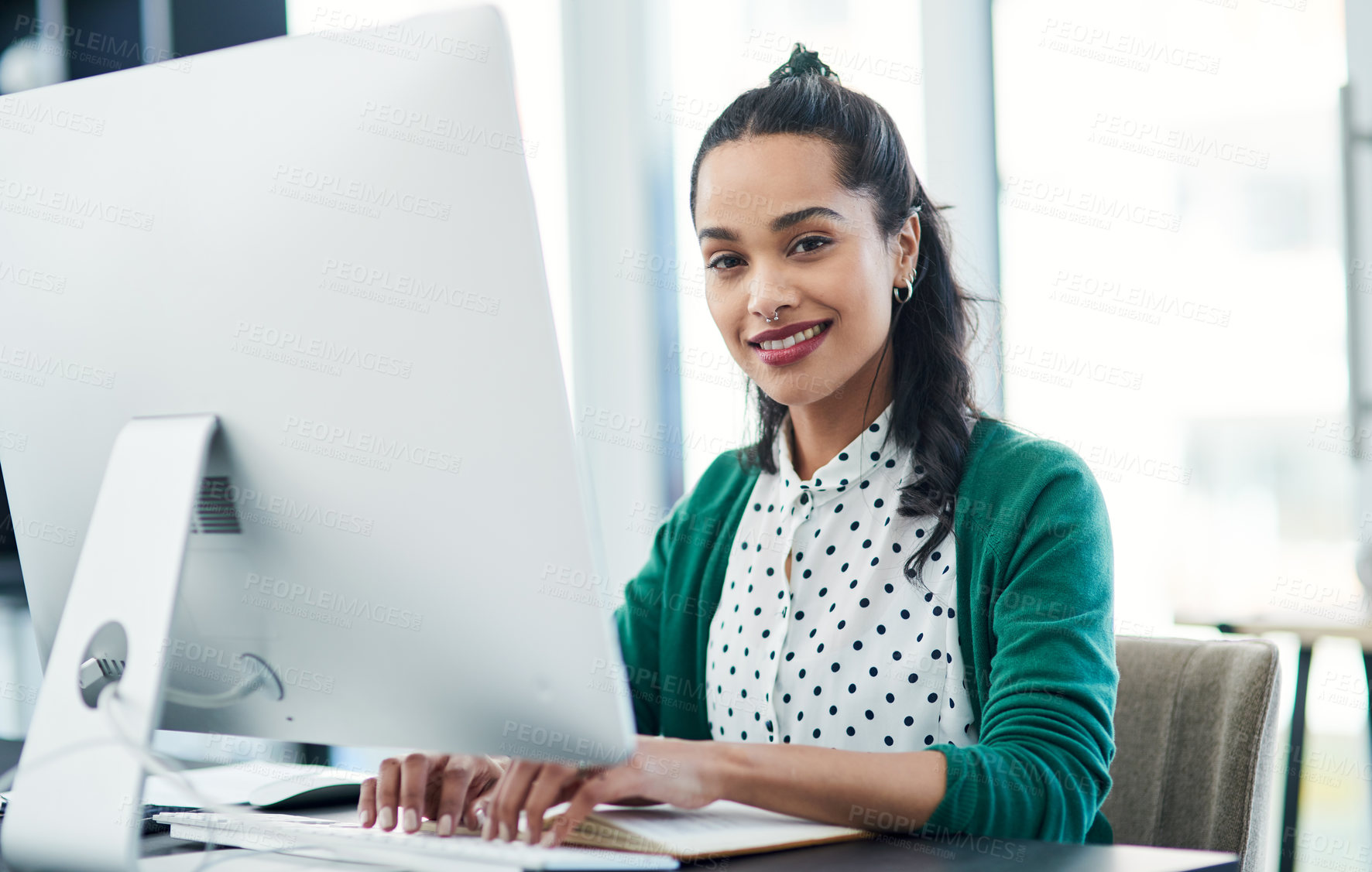 Buy stock photo Portrait of a young businesswoman using a computer in a modern office