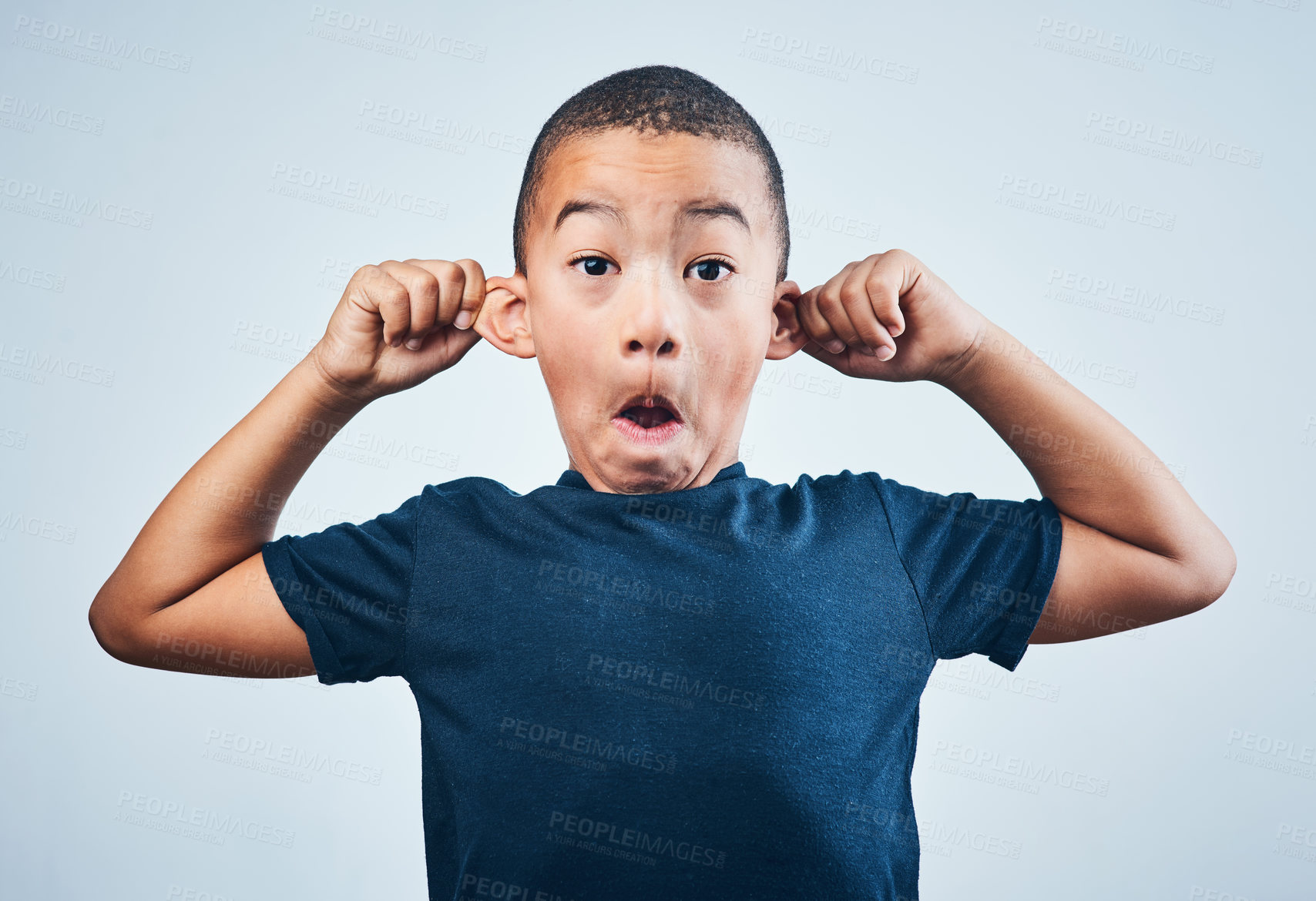 Buy stock photo Boy, portrait and pull ears in studio, playful child and naughty humor on white background. Male person, silly gesture and rebel or quirky kid on backdrop, listening and hearing news or information