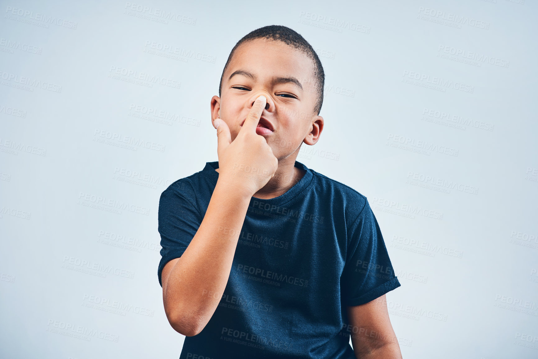 Buy stock photo Studio shot of a cute little boy playfully sticking up his nose against a grey background