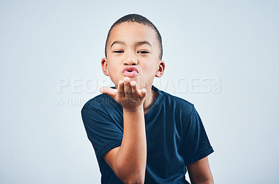 Buy stock photo Studio shot of a cute little boy blowing kisses against a grey background