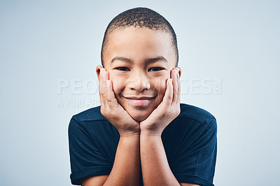 Buy stock photo Portrait, cute boy and kid with happiness, facial expression and relax on gray studio background. Face, childhood and model with emotions, cheerful and joyful with break, calm and peaceful