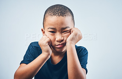 Buy stock photo Studio shot of a cute little boy looking bored against a grey background