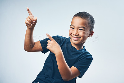 Buy stock photo Studio shot of a cute little boy pointing against a grey background