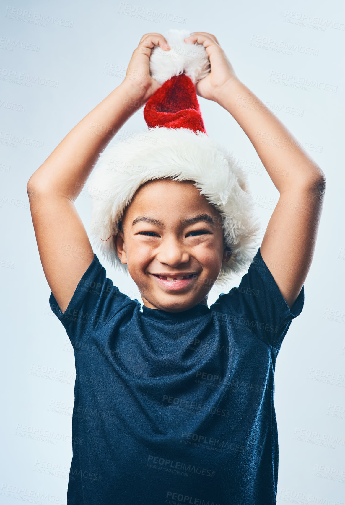 Buy stock photo Studio shot of a cute little boy wearing a Santa hat against a grey background