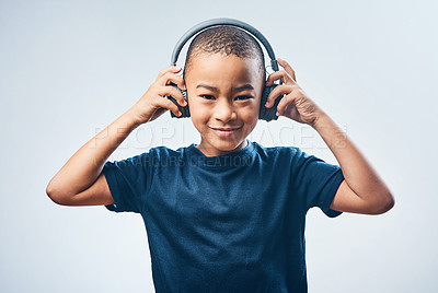 Buy stock photo Studio shot of a cute little boy using headphones against a grey background