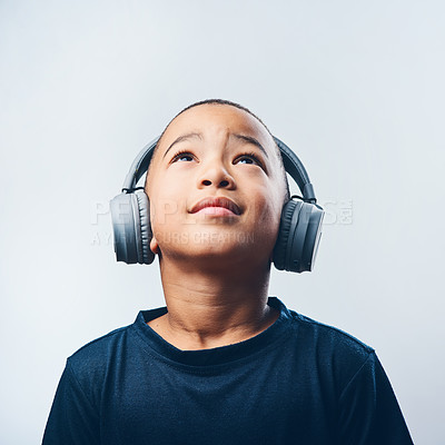 Buy stock photo Boy, kid and headphones for thinking in studio, podcast and listening to sound on white background. Male person, child and tech connect for hearing inspiration, streaming radio and music playlist