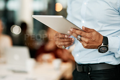 Buy stock photo Cropped shot of a businessman using a digital tablet during a team meeting in a modern office