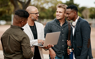 Buy stock photo Shot of a group of businessmen using a laptop against a city background